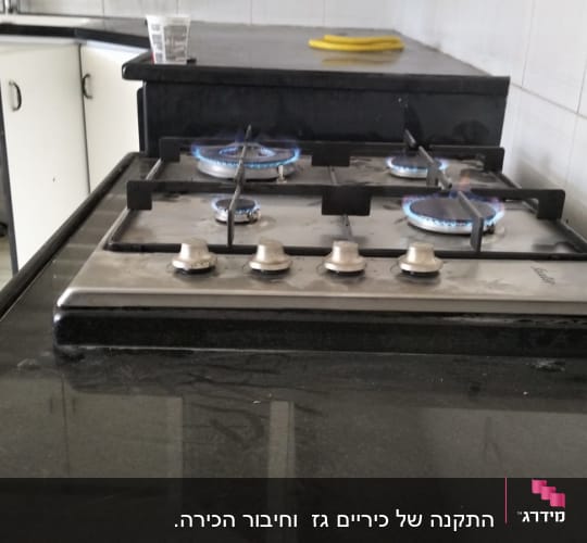כיריים גז עם ארבעה מבערים דולקים במטבח